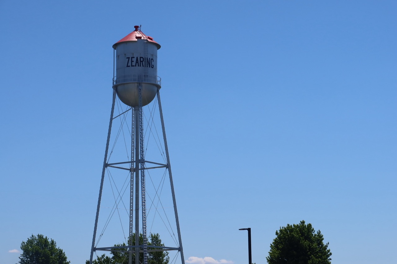 The Zearing water tower, with its red cap, against a clear blue sky